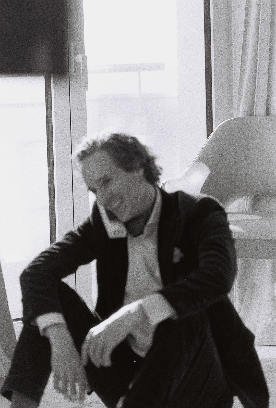 Nikolas Prehn (Felix Nikolas Prehn), seated by a window in a jacket and open shirt, black and white film photograph