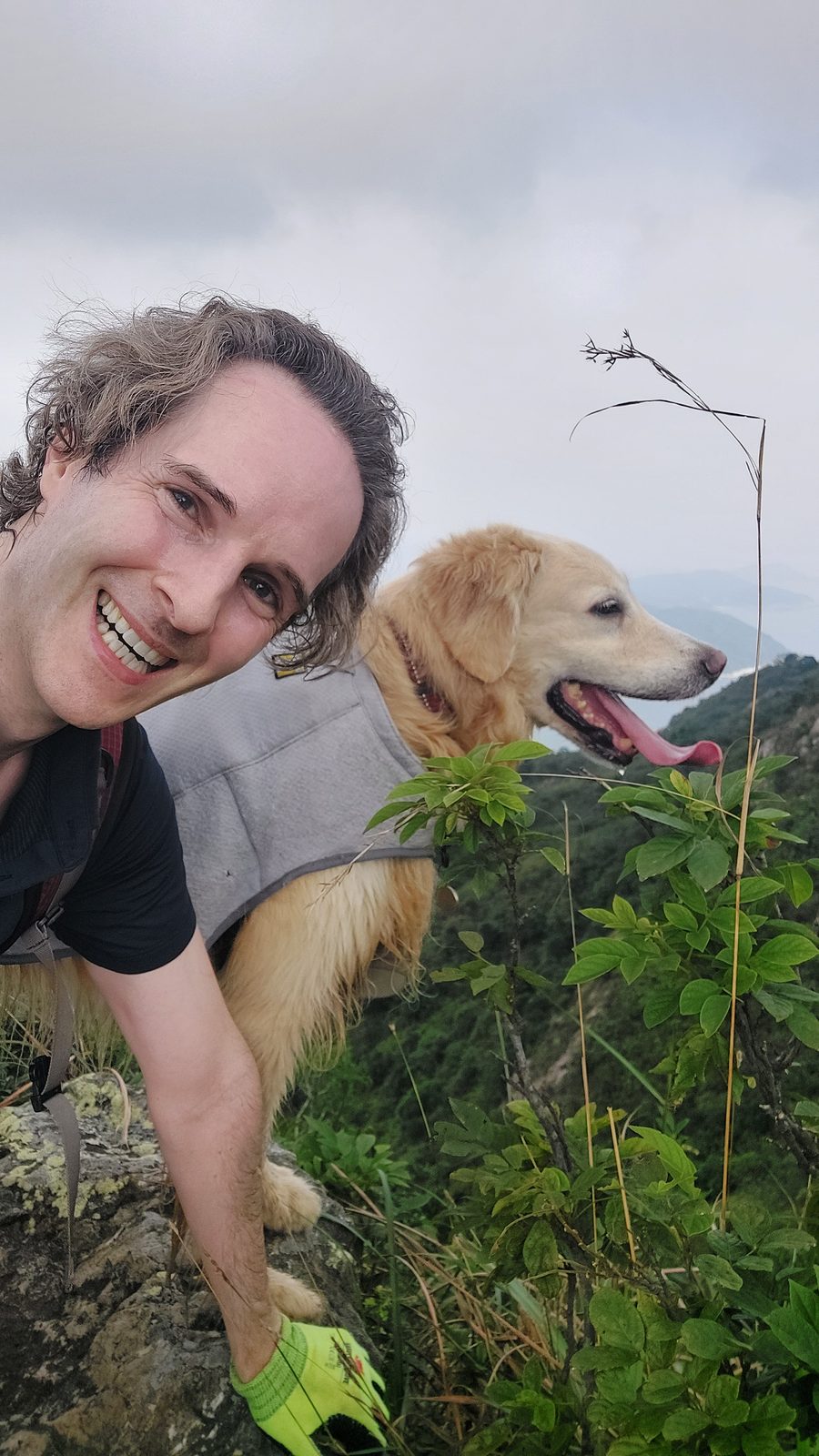 Nikolas Prehn (Felix Nikolas Prehn), on a hillside among green shrubs with his golden retriever Winston