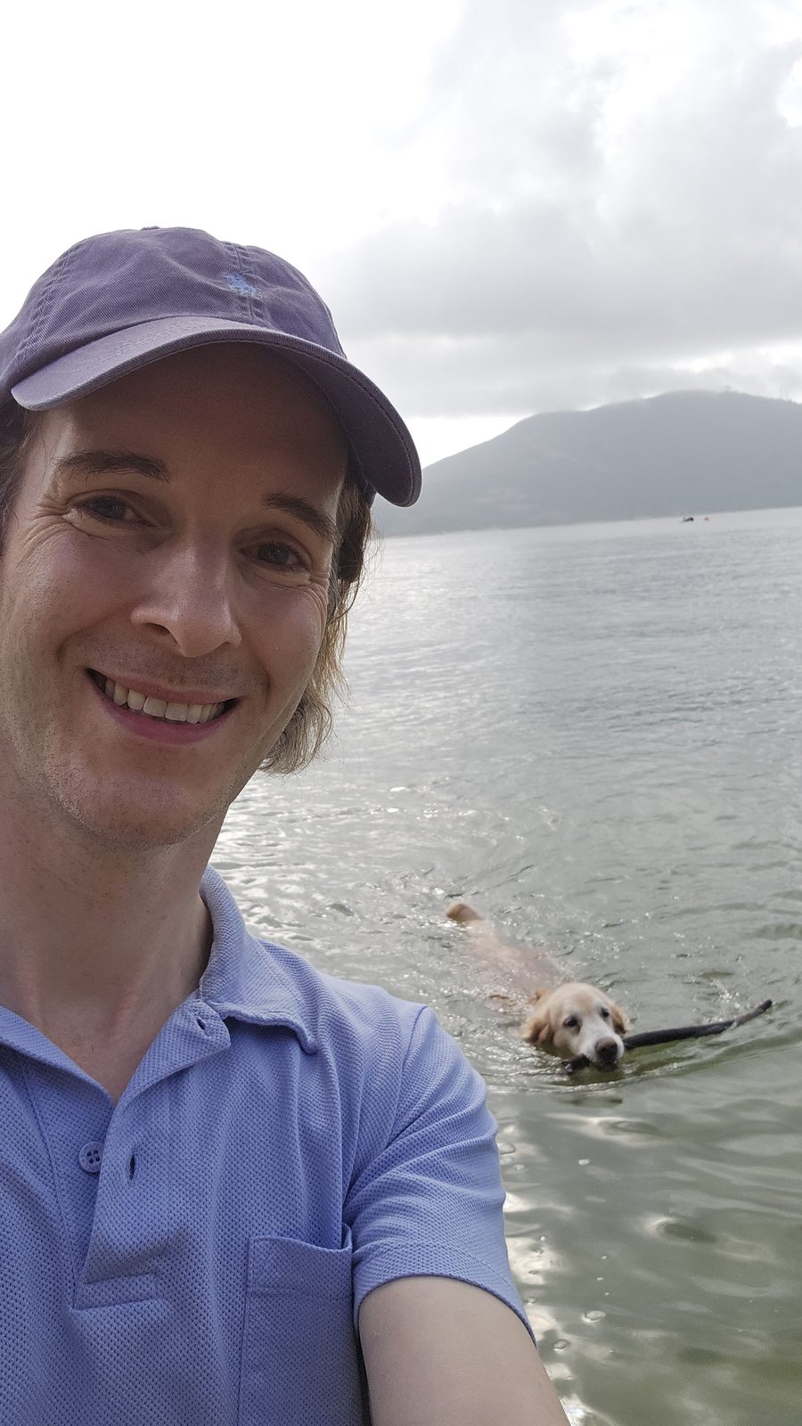 Nikolas Prehn (Felix Nikolas Prehn), in a cap by the sea while Winston swims